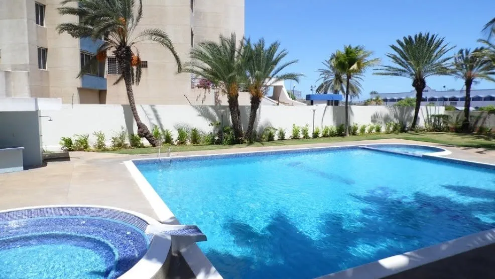 Piscina y jacuzzi de Atenea Suites rodeados de palmeras